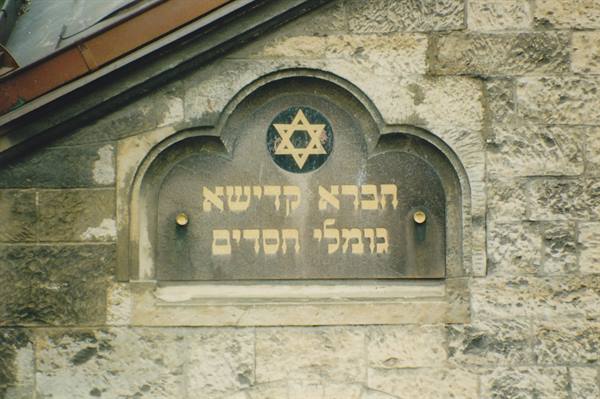 Golden Hebrew plaque with Star of David on gray synagogue stone wall