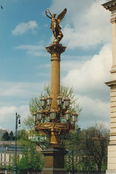 Gilded column with lanterns and winged statue outside Lviv Opera House