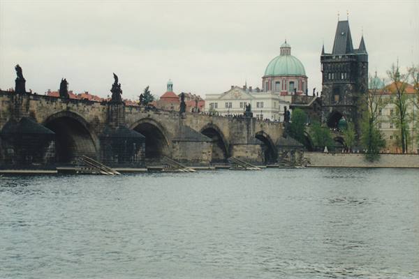 Charles Bridge in Prague: stone arches, statues and Gothic tower above the Vltava