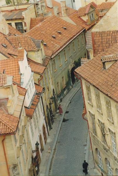 Cobbled street between old houses with red tile roofs, Prague