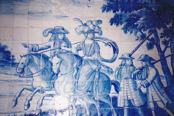 Blue and white azulejo panel with noblemen on horseback and hunters