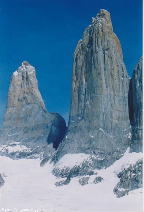 Granite towers of Torres del Paine rising above blue-tinted snow