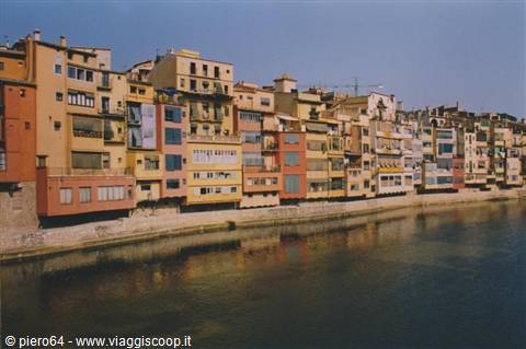 Colorful houses along the Onyar river in Girona, reflected in the water