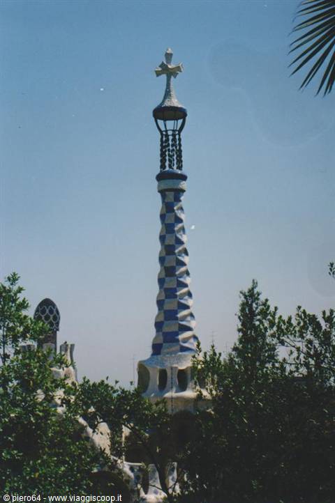 Gaudí's checkered white and blue spire towering over Park Güell