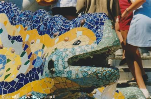 Gaudí's mosaic salamander at Park Güell with tourists nearby