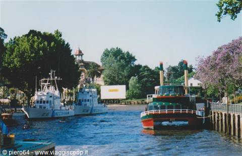 Colorful tour boat and white speedboats moored along the river at Tigre