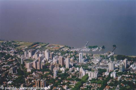 Aerial photo of high-rise buildings and low houses along a wide river