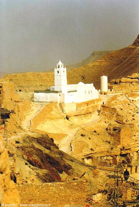 Chenini: white mosque with minaret among earthen Berber village houses