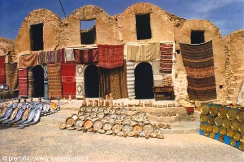 Rug and brass tray sellers in front of Medenine's vaulted ksar granaries