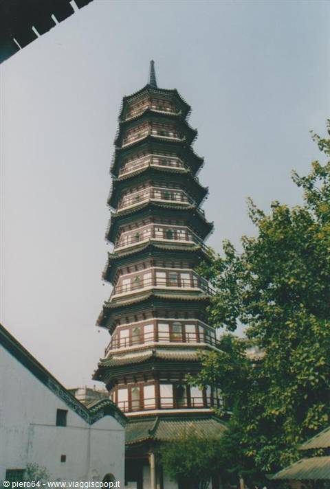 Liu Rong pagoda in Guangzhou, brick and wood tiers among trees under gray sky