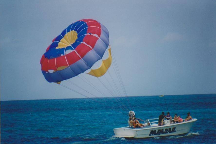 Barca parasail con vela multicolore traina passeggeri sul mare turchese