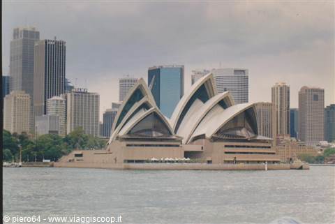 Sydney Opera House with its white sails in front of skyscrapers