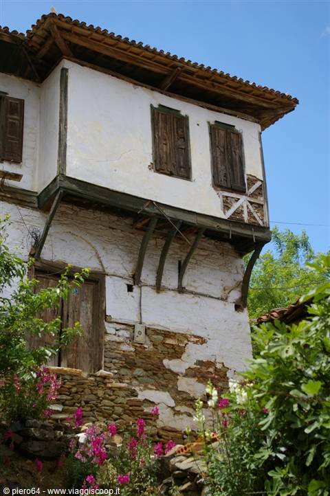 Old Ottoman timber and stone house in Cumalıkızık, pink flowers in front