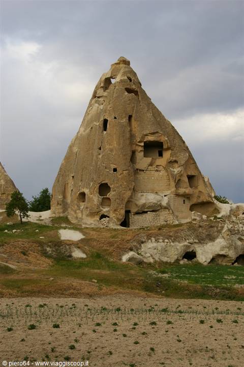 Cappadocia: dwelling carved into tuff rock under a cloudy sky