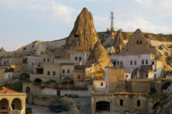 Houses carved in tuff among Göreme fairy chimneys, Cappadocia, golden light
