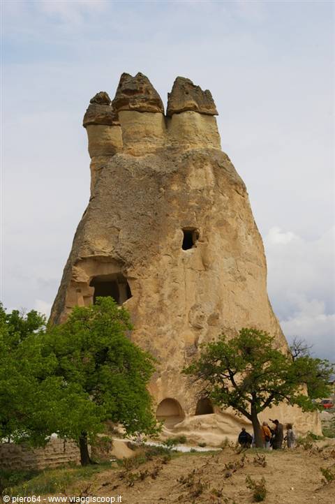 Rock-cut fairy chimneys in Göreme, Cappadocia, tourists at the base