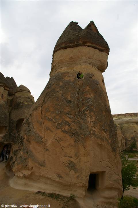 Rock chimney carved with doors and windows, Cappadocia under grey sky
