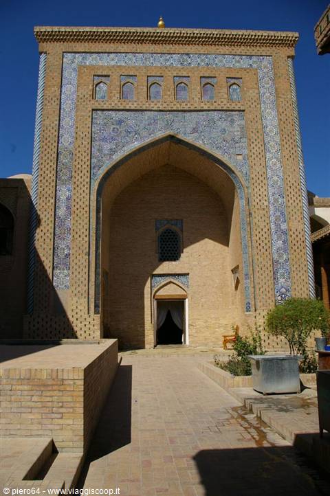 Brick portal with blue tiles of a madrasa in Khiva