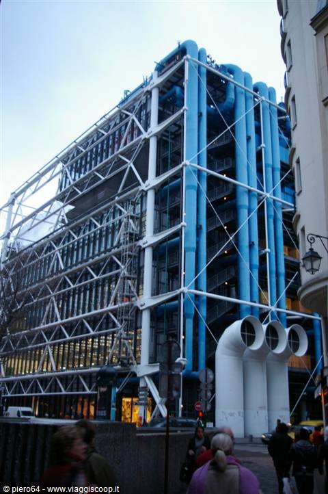 Blue pipes and white steel framework of the Centre Pompidou among pedestrians