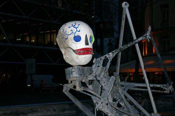 Painted skull sculpture of the Stravinsky Fountain outside Centre Pompidou at night
