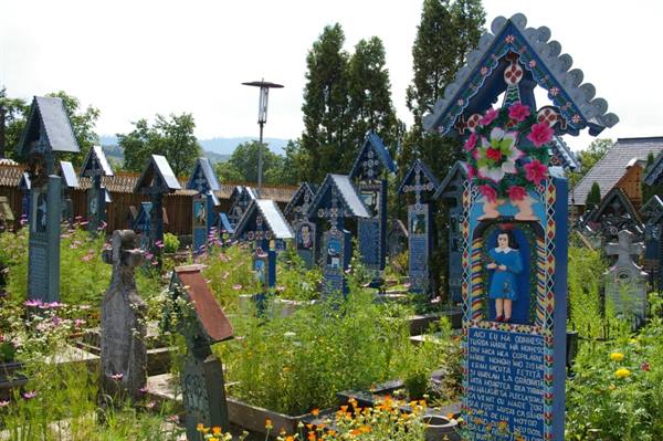 The Merry Cemetery of Săpânța: painted blue wooden crosses among flowers