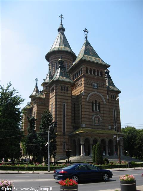 Timișoara Orthodox Cathedral, striped brick and turquoise spires, car passing by