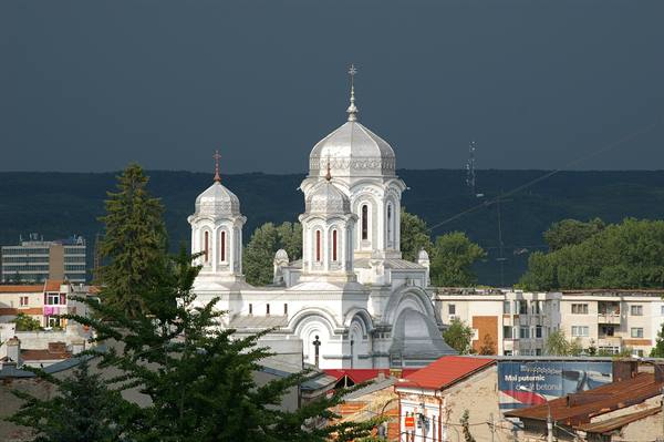 White Orthodox cathedral with silver domes in Sighișoara, stormy sky