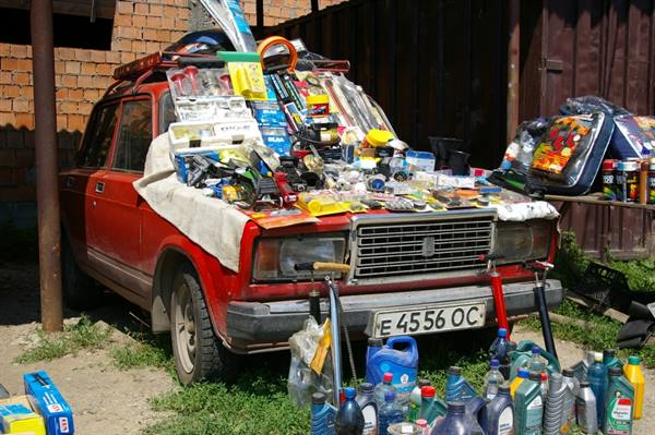 Old red Lada used as a street stall selling tools and car oil