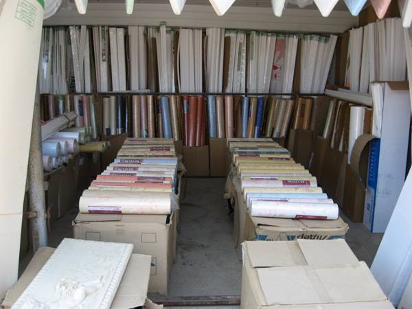 Wallpaper rolls in cardboard boxes inside a small warehouse