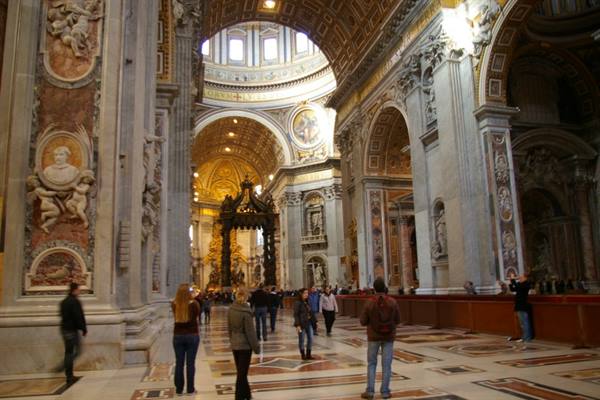 Visitors beneath Bernini's baldachin inside St. Peter's Basilica