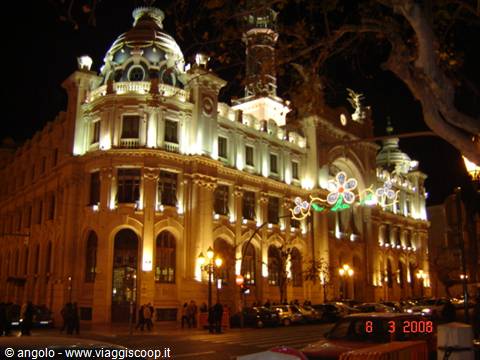 Illuminated post office building at night in Barcelona, golden lights on domes