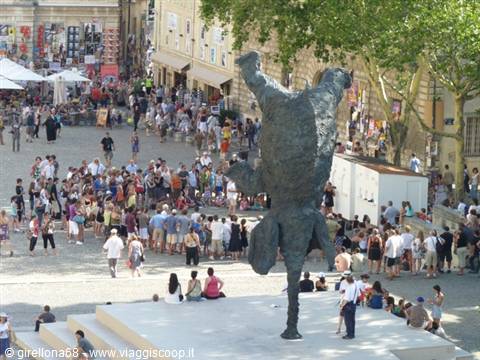 Elephant statue balancing on its trunk, crowded square in Avignon