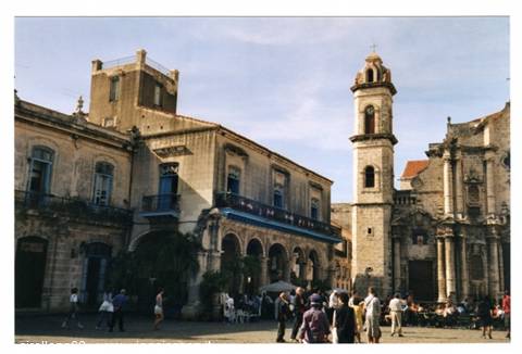 Tourists stroll through Plaza de la Catedral before the weathered baroque cathedral