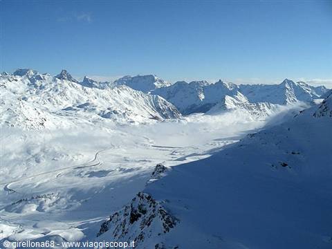 Snow-covered peaks under blue sky, sunlit slopes and shadows