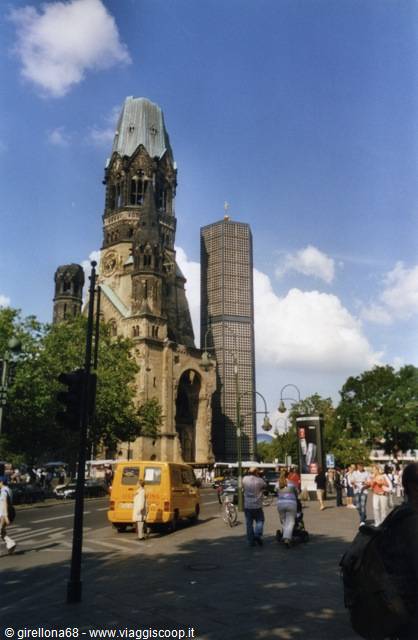 Kaiser Wilhelm Memorial Church in Berlin, ruined tower, yellow van and pedestrians