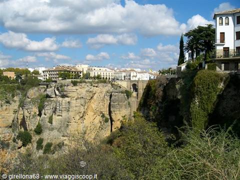Ronda: white houses and hotel perched above the Tajo gorge, arched bridge crossing rocks