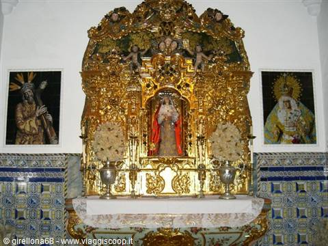 Gilded altar with Madonna statue, white flower vases, religious paintings and azulejo tiles
