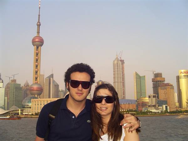 Couple wearing sunglasses on the Bund, Oriental Pearl Tower behind in Shanghai