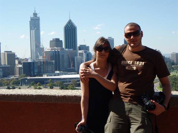 Couple with cameras in front of Perth skyscrapers, sunny daylight