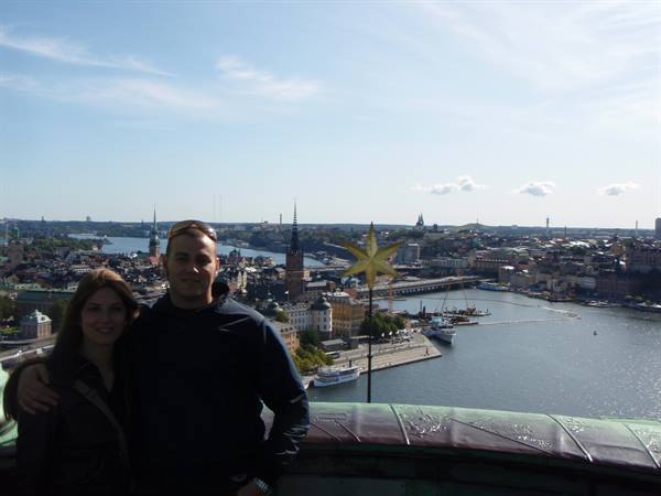 Couple on a Stockholm terrace, sunny city and water behind them