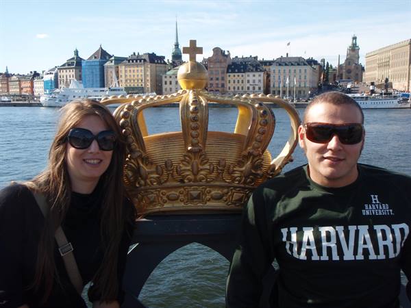 Couple in sunglasses beside the golden crown on Skeppsholmsbron bridge, Stockholm