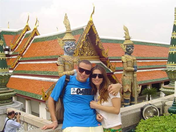 Couple posing before the giant demon guardians at Wat Phra Kaew