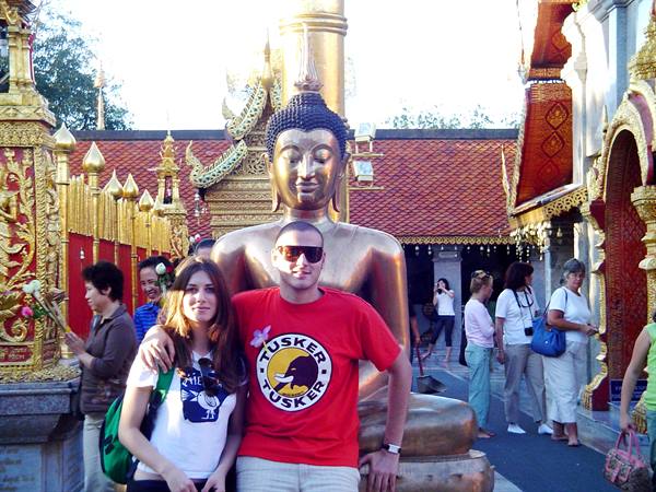 Tourists posing before a large bronze Buddha at Wat Phra That Doi Suthep