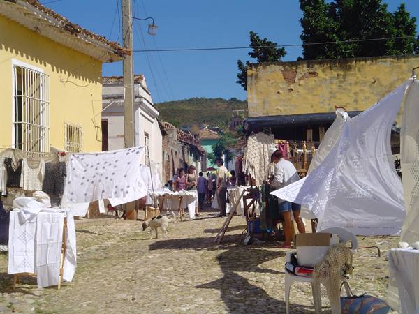 Embroidered tablecloth market on Trinidad cobblestone street, under bright sun