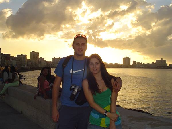 Couple with camera on the Havana Malecón seawall at sunset
