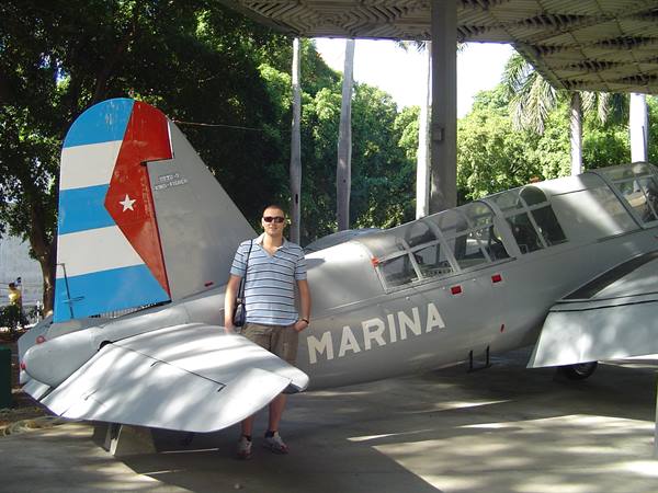 Tourist beside a gray military plane with Cuban tail and MARINA writing
