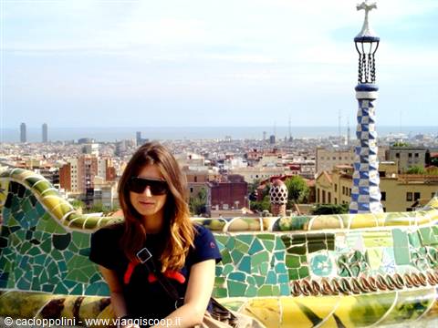 Tourist in sunglasses on the wavy mosaic bench, Park Güell, Barcelona