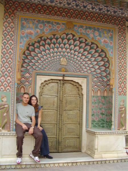 Couple sitting before the floral painted doorway of Jaipur's City Palace
