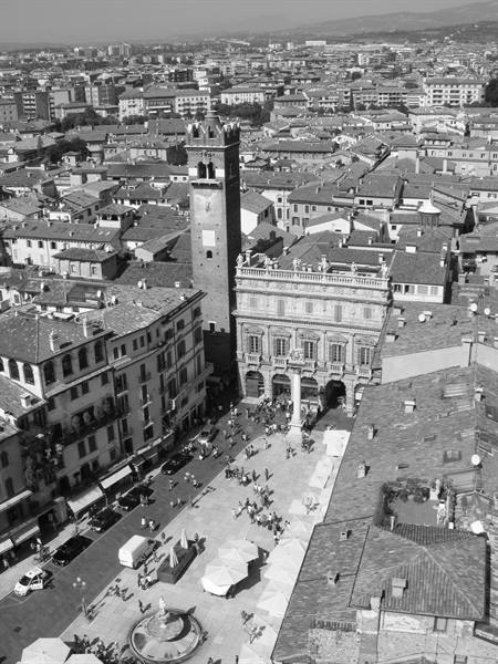 Verona, Piazza delle Erbe with Lamberti Tower and crowds among rooftops