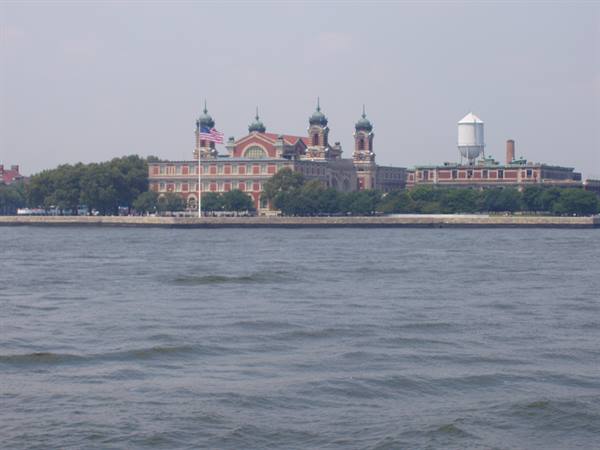 Ellis Island: brick building with towers, American flag and water tower